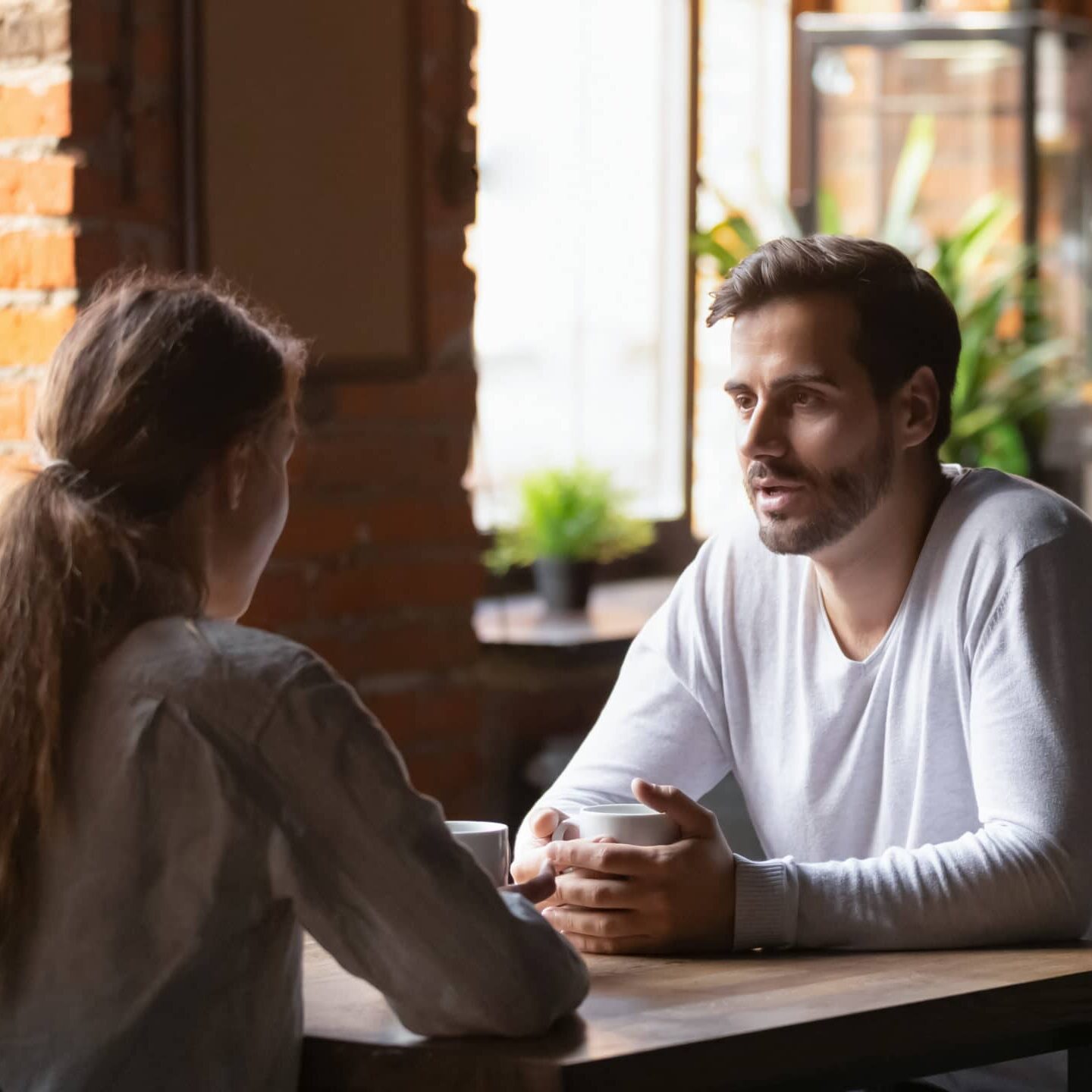 Millennial,Couple,Sit,At,Cafe,Table,Drinking,Hot,Coffee,Talking